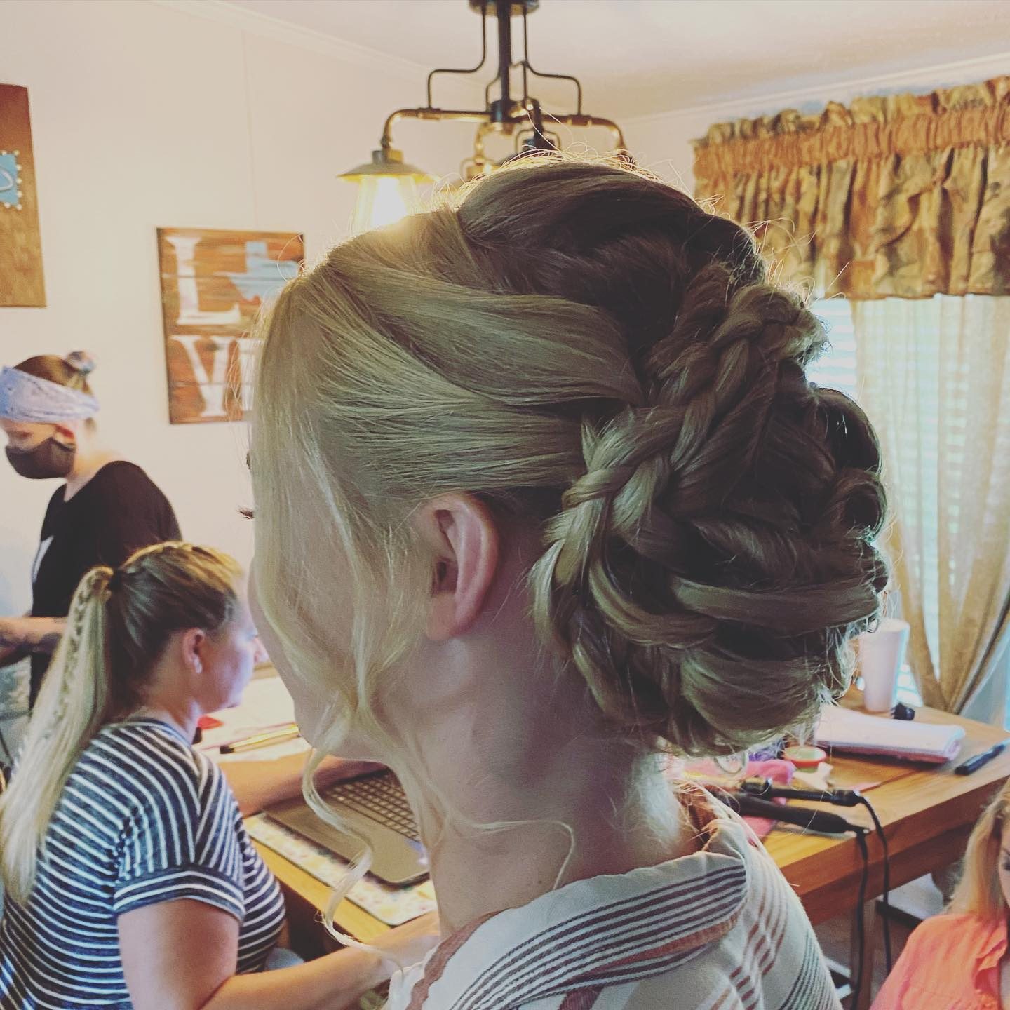 Close portrait of a smiling blonde bride in a blush robe with a swept-back updo and soft smoky eye